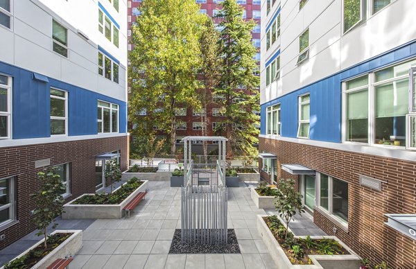 Zig Apartments: Serene courtyard with lush greenery and seating areas