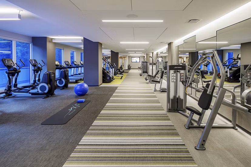 Fully-equipped fitness center featuring modern workout machines at Exo Apartments