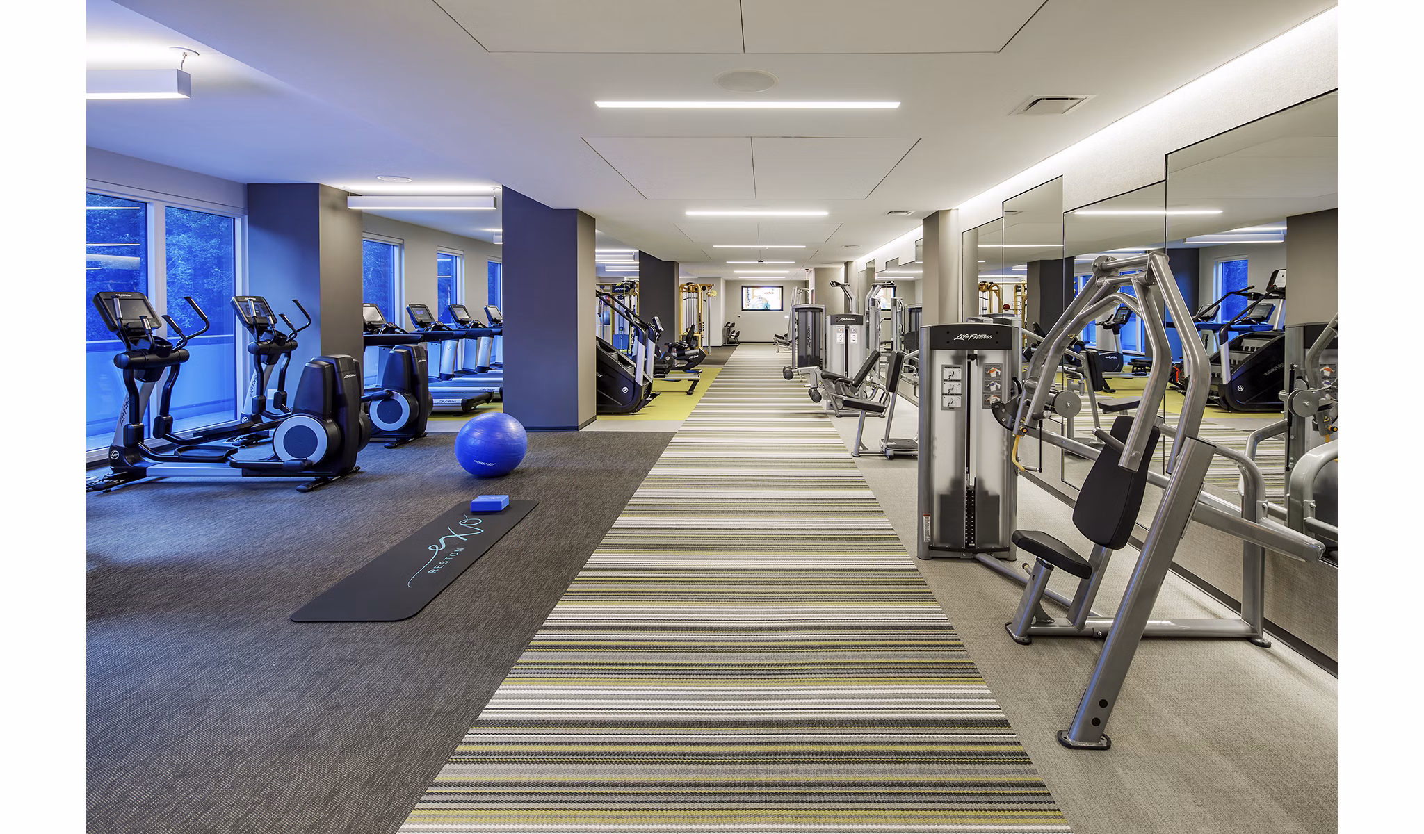 Fully-equipped fitness center featuring modern workout machines at Exo Apartments