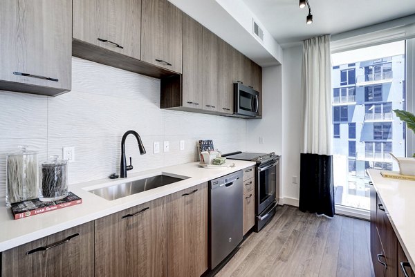 Modern kitchen with stainless steel appliances in Exo Apartments