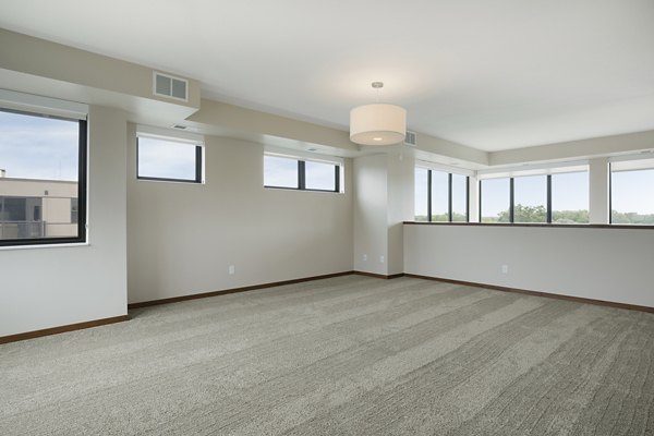 Cozy bedroom featuring plush bedding and modern decor at Ellipse on Excelsior luxury apartments