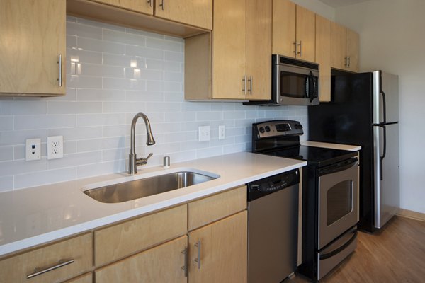 Kitchen with granite countertops and stainless steel appliances at Ellipse on Excelsior luxury apartments
