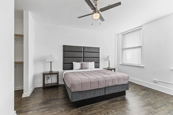 Spacious bedroom with vintage charm at Historic Electric Building Apartments, featuring large windows and classic design elements