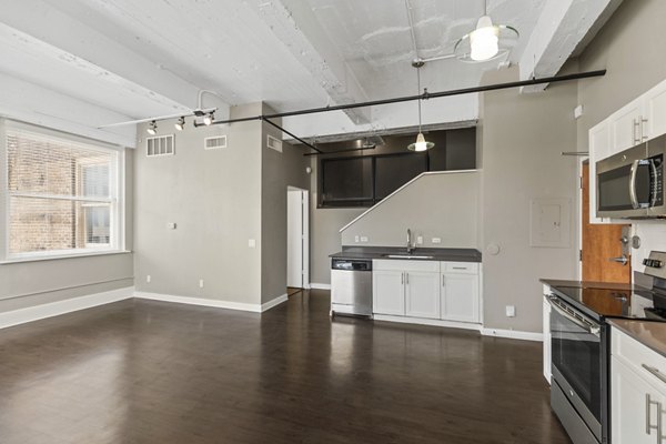 Modern kitchen with stainless steel appliances and granite countertops in Historic Electric Building Apartments