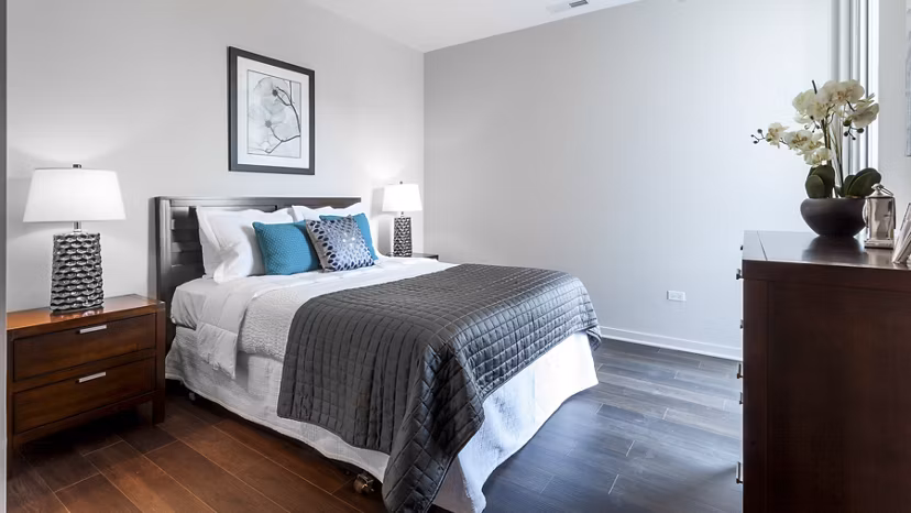 Comfortable bedroom with modern furniture and decor at Luxe on Chicago Apartments