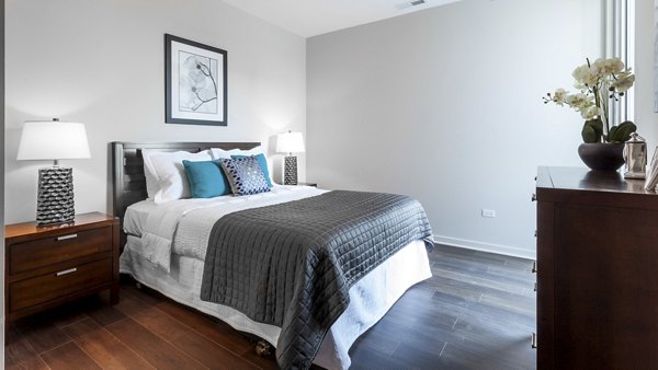Comfortable bedroom with modern furniture and decor at Luxe on Chicago Apartments