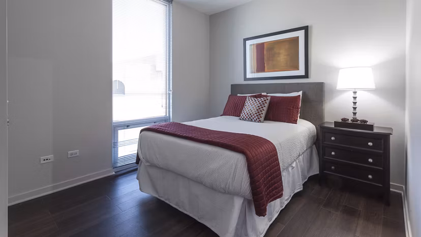 Bedroom featuring plush bedding and modern decor at Luxe on Chicago Apartments