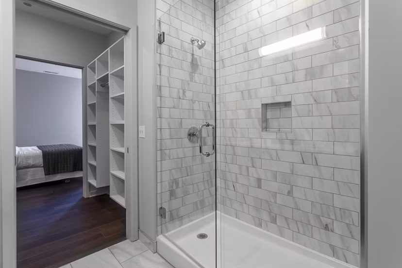 Modern bathroom with glass shower and sleek fixtures at Luxe on Chicago Apartments