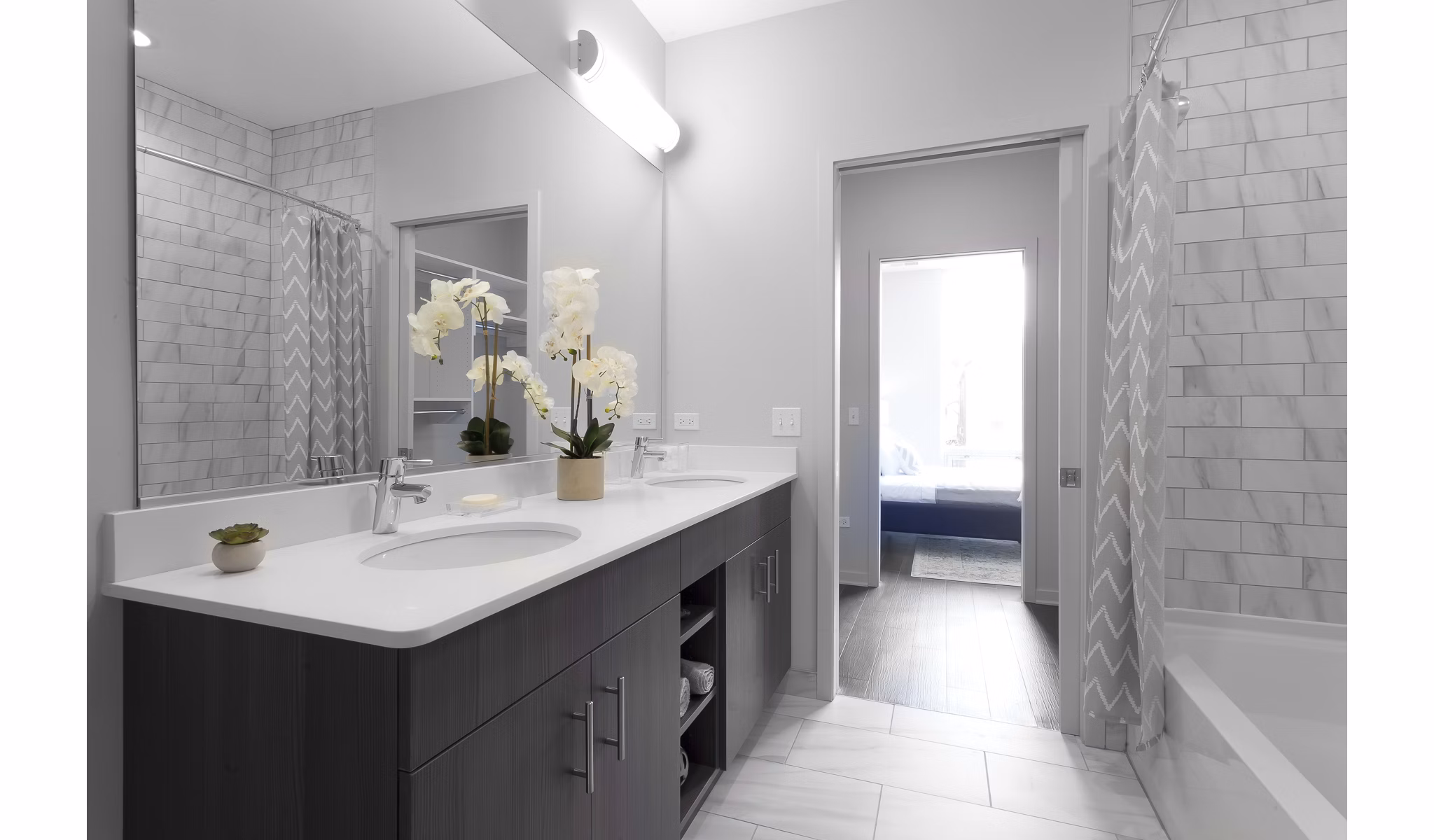 Modern bathroom with glass shower and sleek fixtures at Luxe on Chicago Apartments