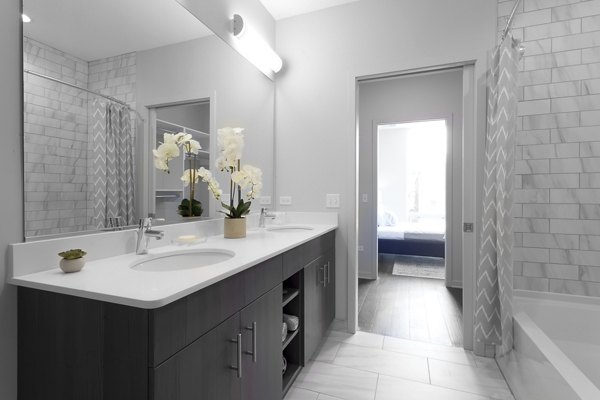 Modern bathroom with glass shower and sleek fixtures at Luxe on Chicago Apartments
