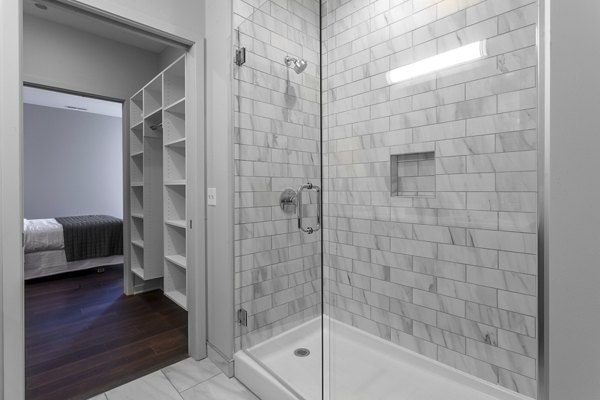 Elegant bathroom with marble finishes and modern fixtures at Luxe on Chicago Apartments