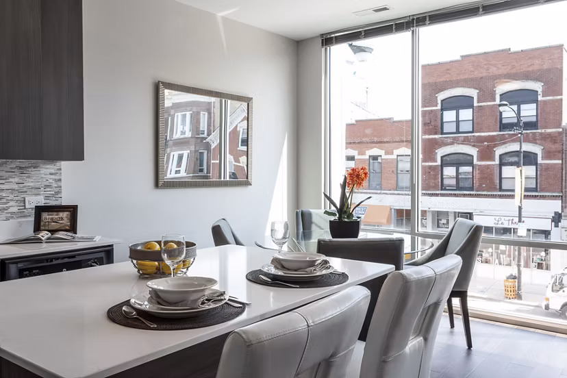 Dining area featuring modern decor and large windows at Luxe on Chicago Apartments