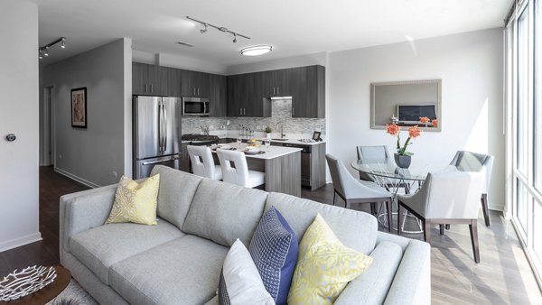 Spacious living room with modern decor and large windows in Luxe on Chicago Apartments