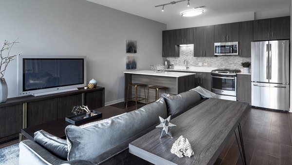Spacious living room with modern decor and large windows at Luxe on Chicago Apartments, offering urban luxury in a vibrant neighborhood