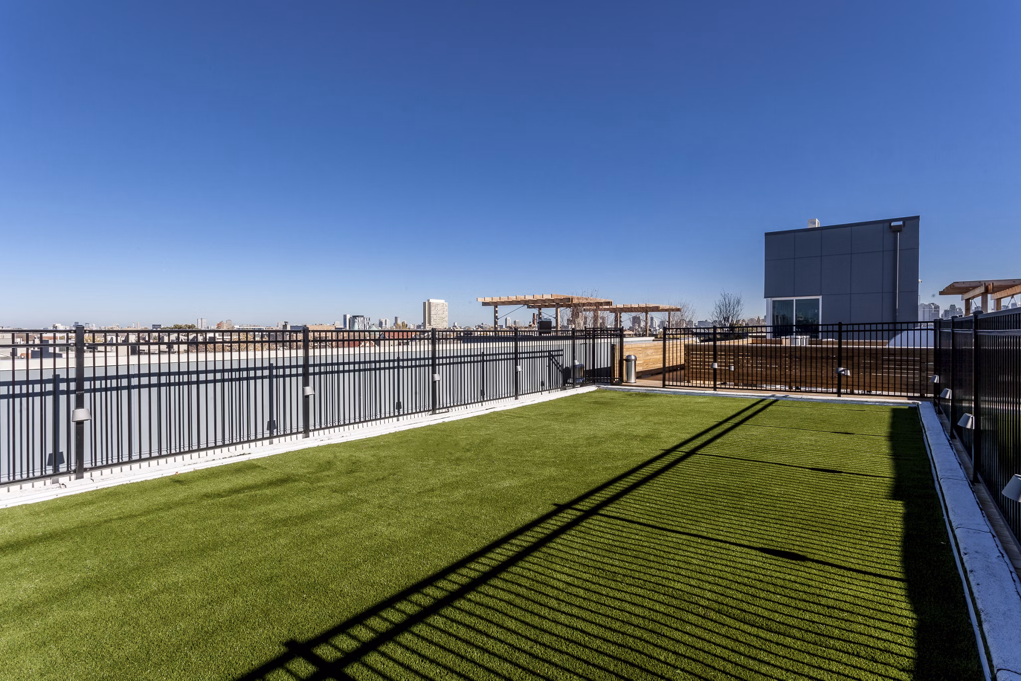 Dog-friendly dog park at Luxe on Chicago Apartments featuring agility equipment for resident pets
