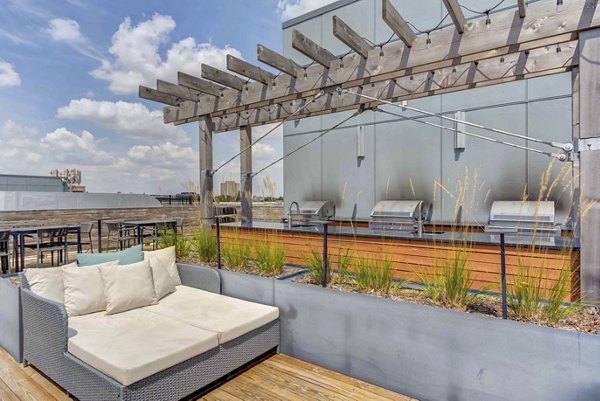 Modern outdoor grill area at Luxe on Chicago Apartments, featuring stainless steel grills and seating for community gatherings