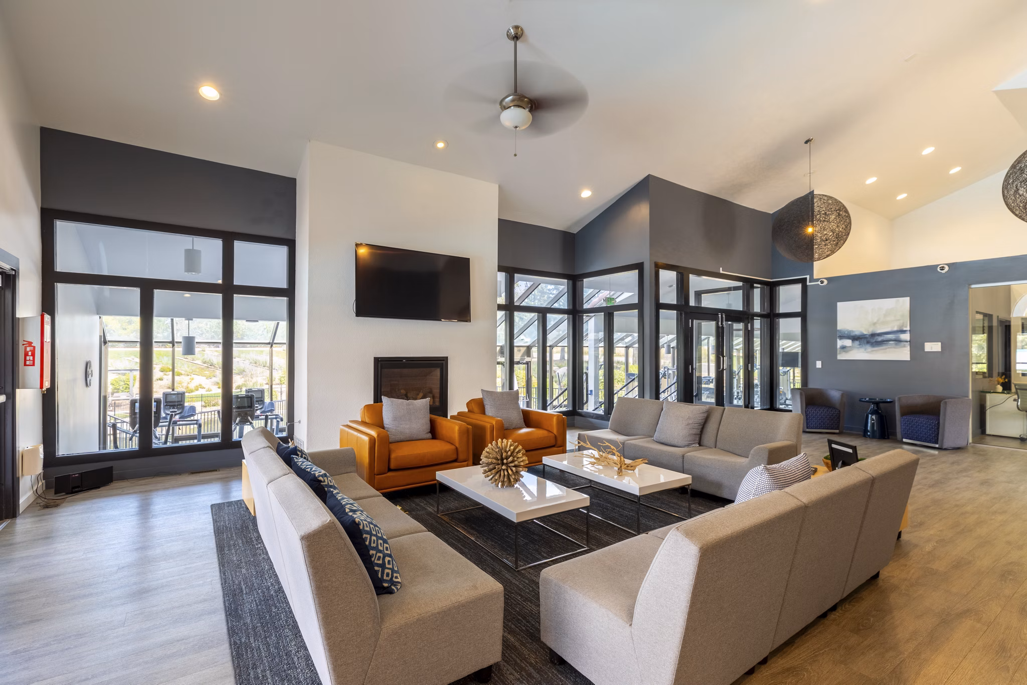 Modern clubhouse with communal seating and large-screen TVs at Reflections on 92nd Apartments