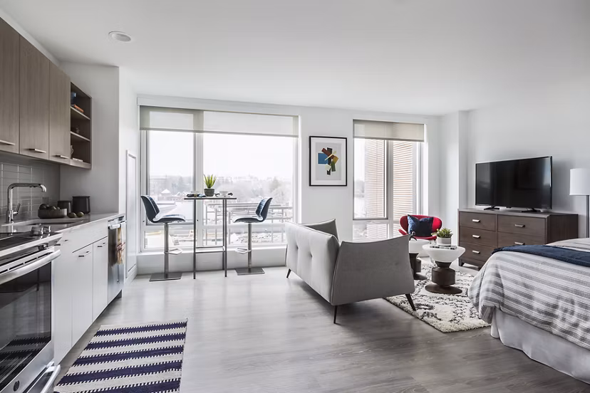 Spacious living room with modern decor and ample lighting in Lantera at Boston Landing Apartments