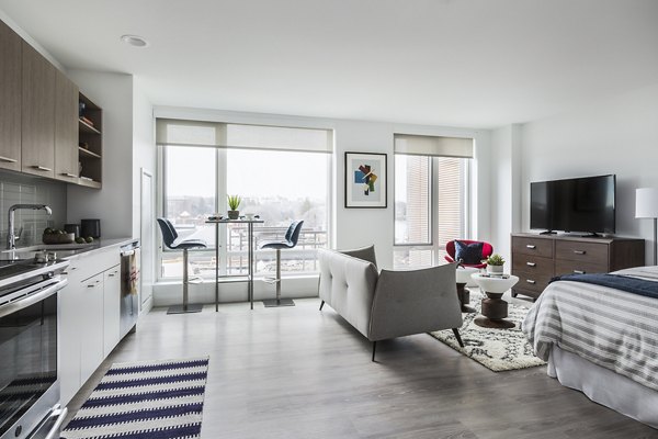 Spacious living room with modern decor and ample lighting in Lantera at Boston Landing Apartments