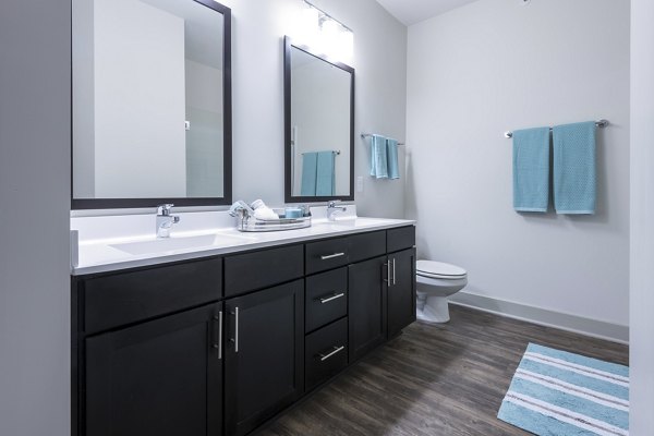 Elegant bathroom featuring marble countertops and spacious shower at The Franklin at Crossroads Apartments