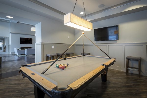 Game room with pool table and cozy seating at The Franklin at Crossroads Apartments, offering a luxury recreation space for residents