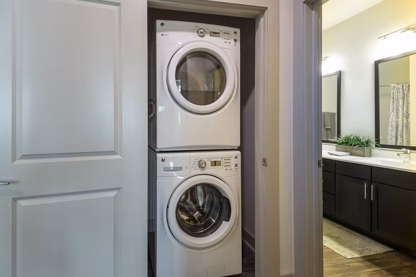 Modern laundry room with high-efficiency washers and dryers at The Franklin at Crossroads Apartments