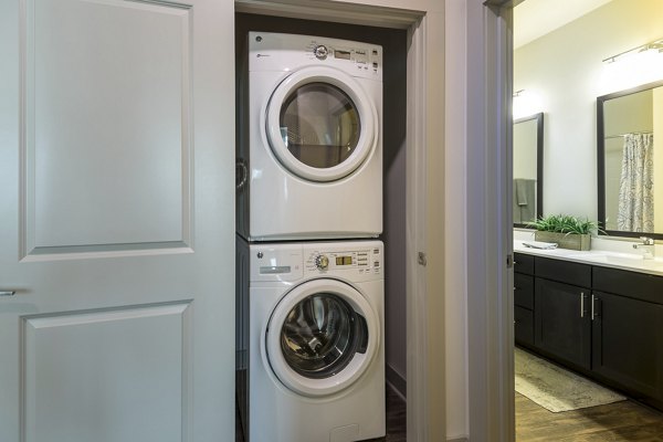 Modern laundry room with high-efficiency washers and dryers at The Franklin at Crossroads Apartments