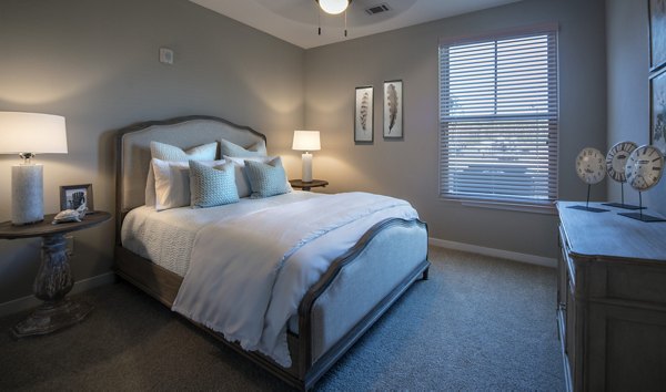 Cozy bedroom with stylish decor at One Hampton Lake Apartments, offering luxury living at Greystar's premier community