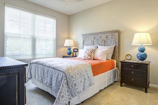 Bedroom with elegant decor and large windows at Grand Oaks at Crane Creek Apartments