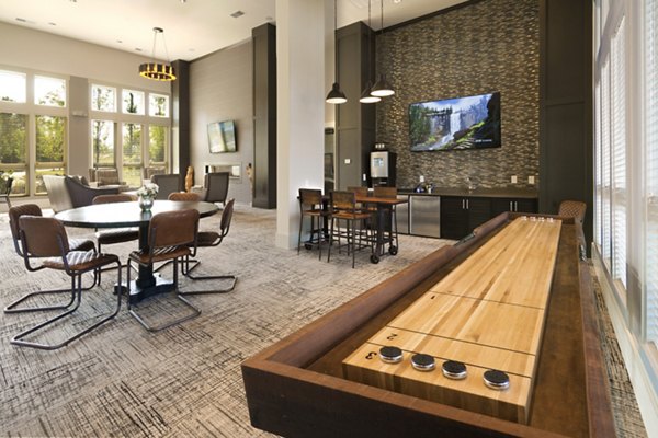 Clubhouse game room with pool table and lounge area at Grand Oaks at Crane Creek Apartments
