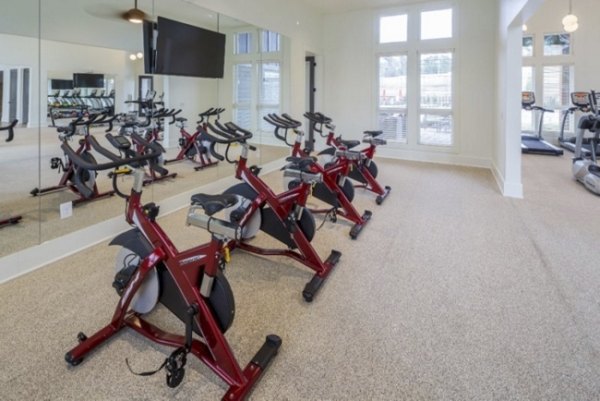 Spin studio with modern bikes and mirrors at Grand Oaks at Crane Creek Apartments, ideal for fitness enthusiasts