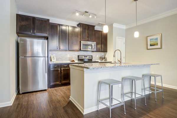 Grand Oaks at Crane Creek: Modern kitchen with stainless steel appliances and granite countertops in luxury apartments