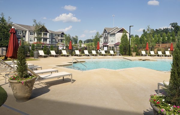 Inviting pool area surrounded by lush landscaping at Grand Oaks at Crane Creek Apartments
