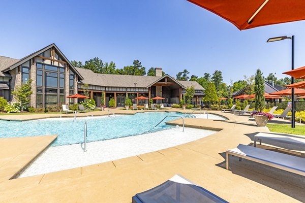 Resort-style swimming pool at Grand Oaks at Crane Creek Apartments with lounge seating and palm trees