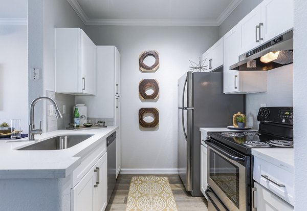 Modern kitchen with stainless steel appliances and granite countertops at Avana Eastlake Apartments