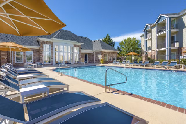 Poolside relaxation area at Avana Eastlake Apartments with lounge chairs and landscaped views