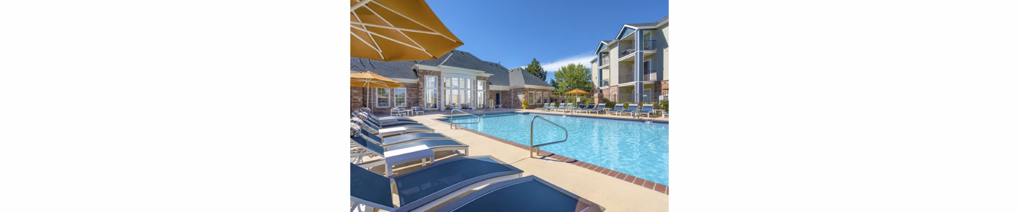 Poolside relaxation area at Avana Eastlake Apartments with lounge chairs and landscaped views