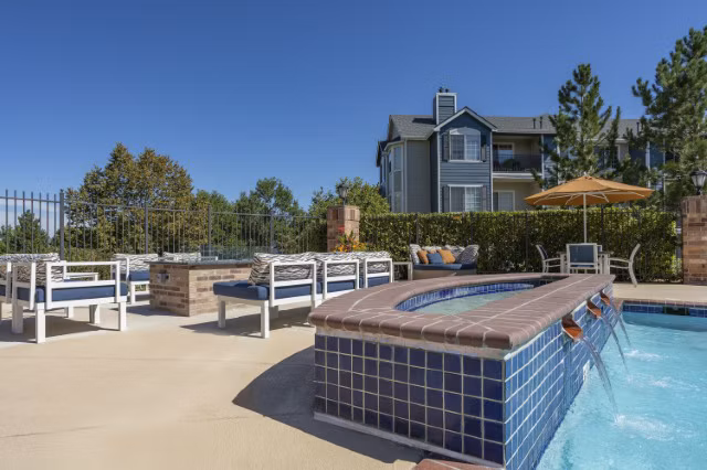 Cozy fire pit seating area at Avana Eastlake Apartments with surrounding lush greenery