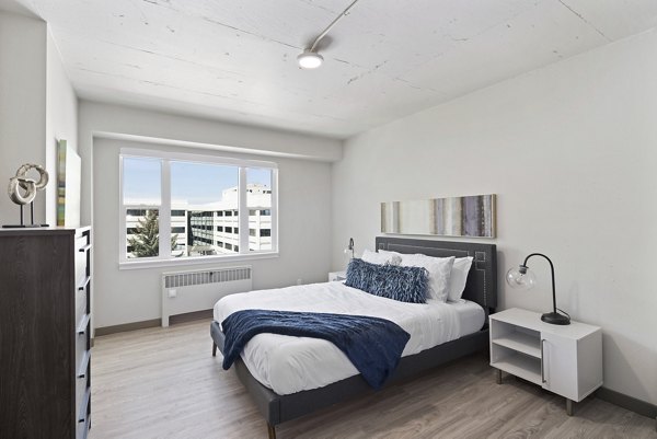 Luxury bedroom with elegant decor at Cooper George Apartments, featuring modern furnishings and large windows for natural light