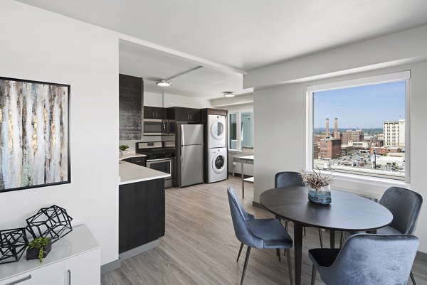 Spacious dining area with modern decor in Cooper George Apartments, featuring elegant furnishings and ambient lighting for luxury living