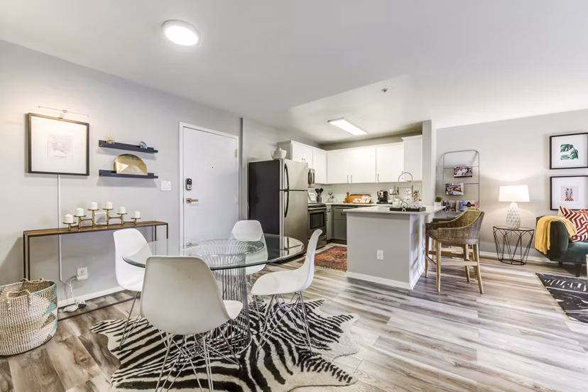 Dining area with elegant furnishings and modern lighting at Avana on Pine Apartments