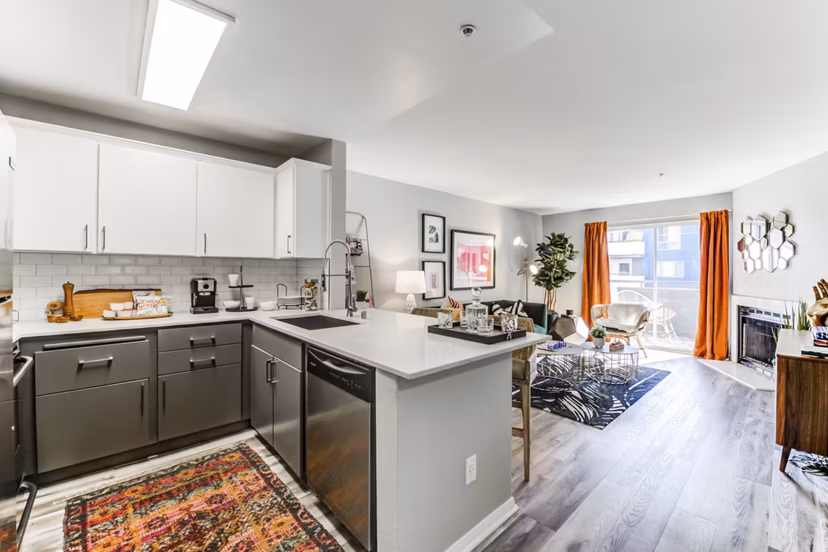 Modern kitchen with granite countertops and stainless steel appliances at Avana on Pine Apartments