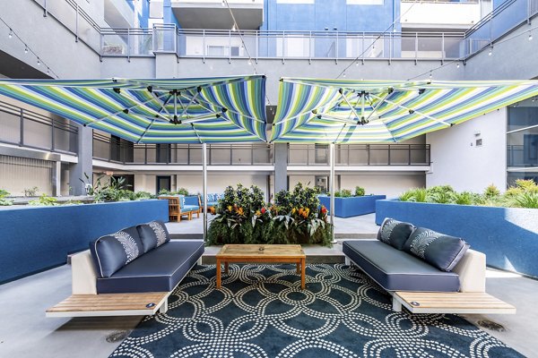 Tranquil courtyard with lush greenery at Avana on Pine Apartments, featuring comfortable seating and pathways