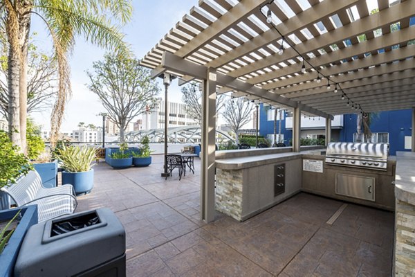 Outdoor grill area with modern seating at Avana on Pine Apartments, ideal for hosting gatherings in a luxury setting