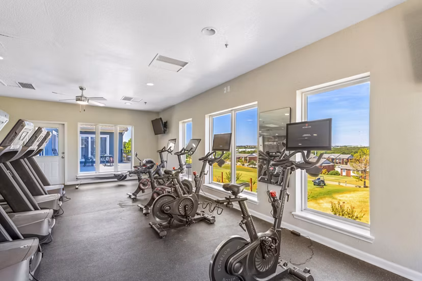Modern fitness center with cardio and weight equipment at Timberlinks at Denton Apartments for active living