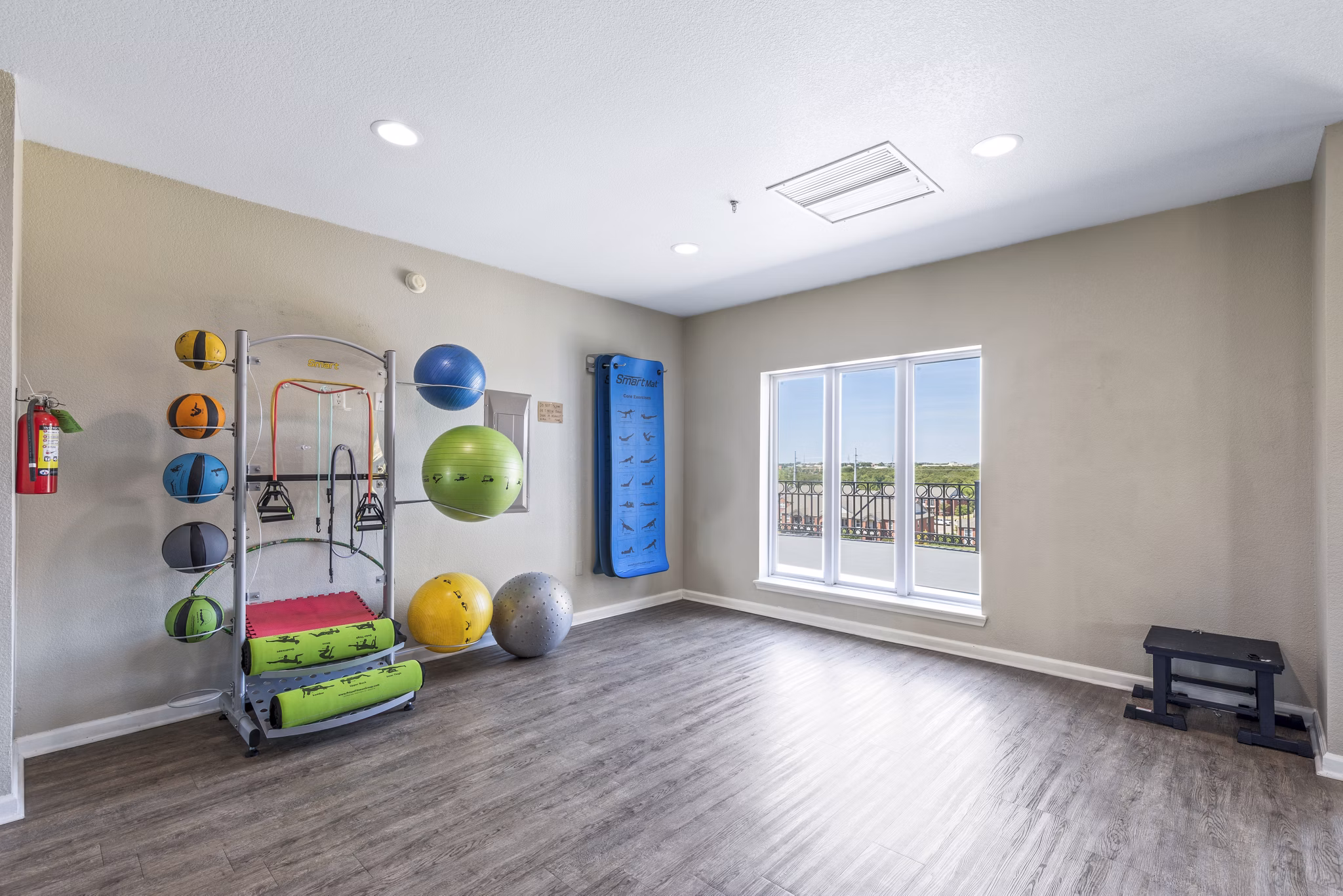 Yoga studio with hardwood floors and mirrors at Timberlinks at Denton Apartments offering fitness amenities and community wellness spaces