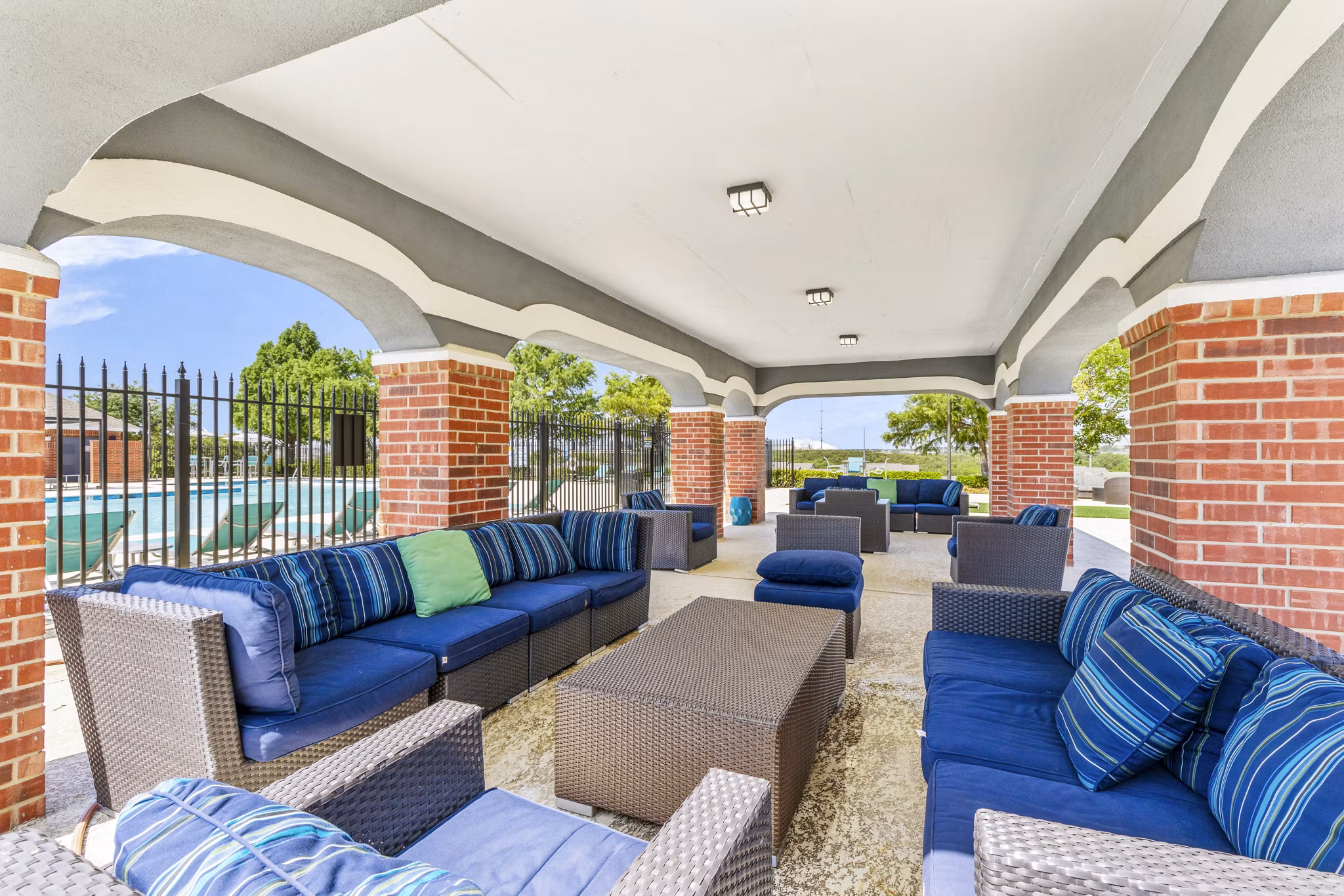 Modern outdoor patio space with seating and BBQ grill at Timberlinks at Denton Apartments