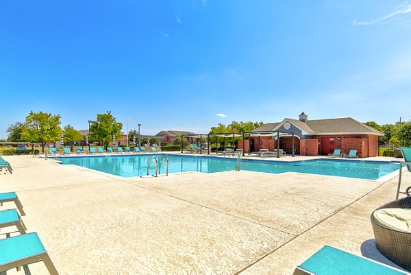 Outdoor pool with lounge chairs at Timberlinks at Denton Apartments offering relaxation and recreation in a luxury setting