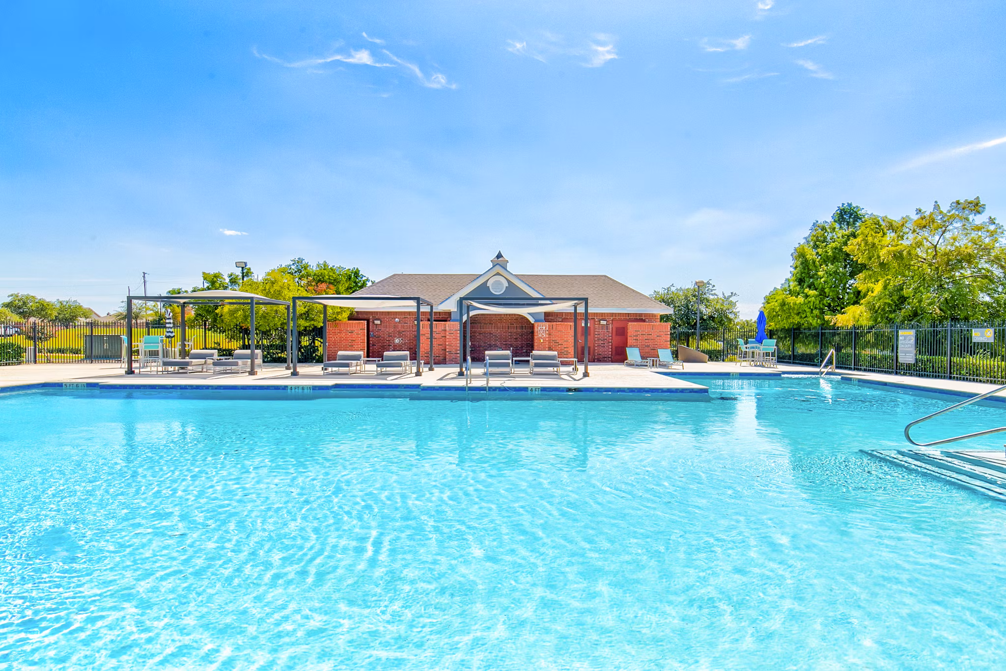 Serene outdoor pool with lounge chairs at Timberlinks at Denton Apartments