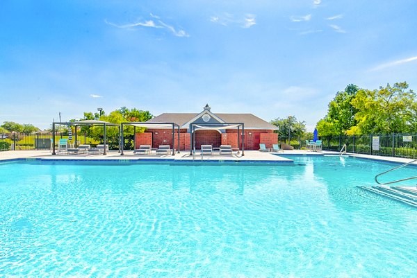 Serene outdoor pool with lounge chairs at Timberlinks at Denton Apartments